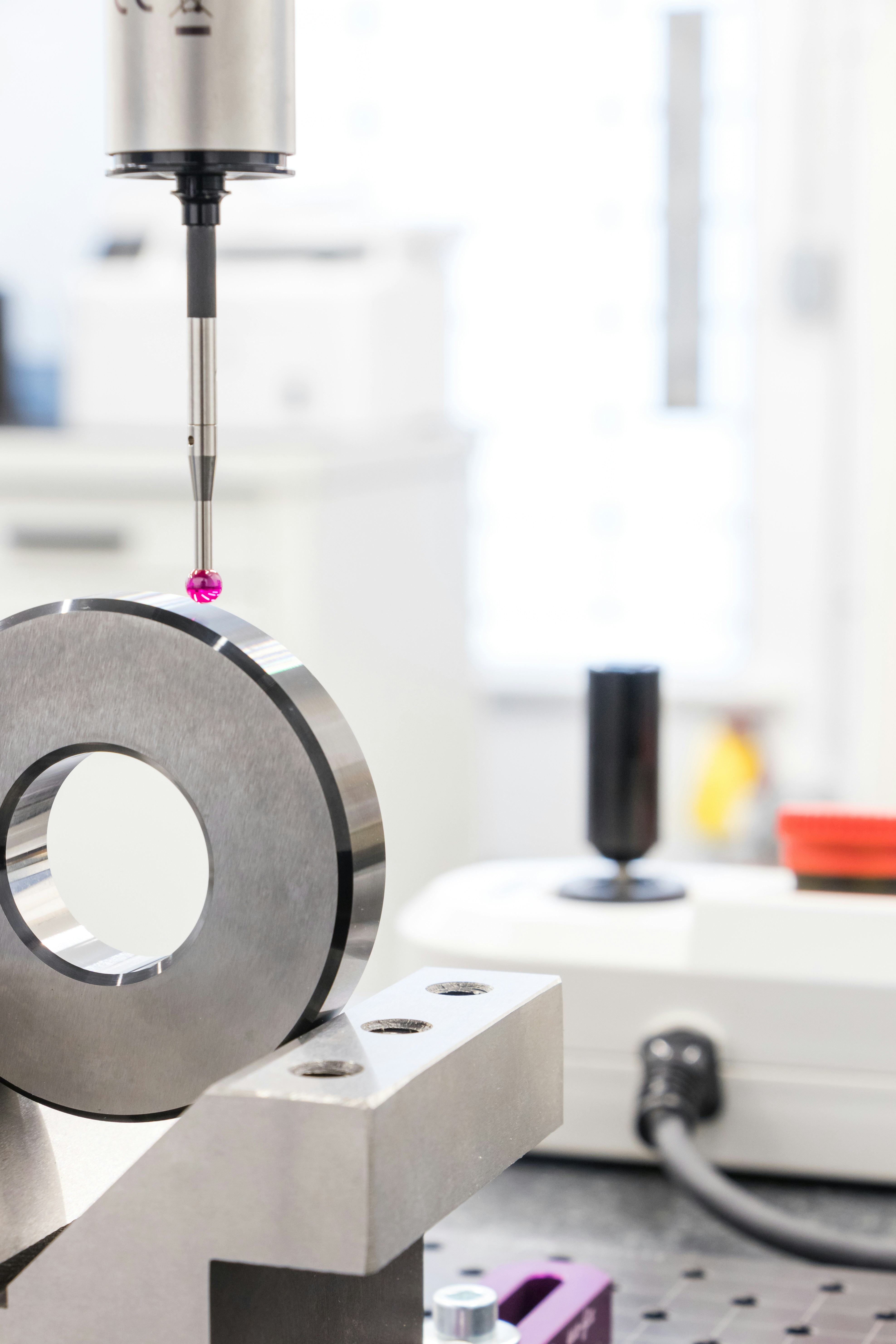 Quality control inspector examining manufactured products using precision measuring tools, factory floor environment with production line visible in background